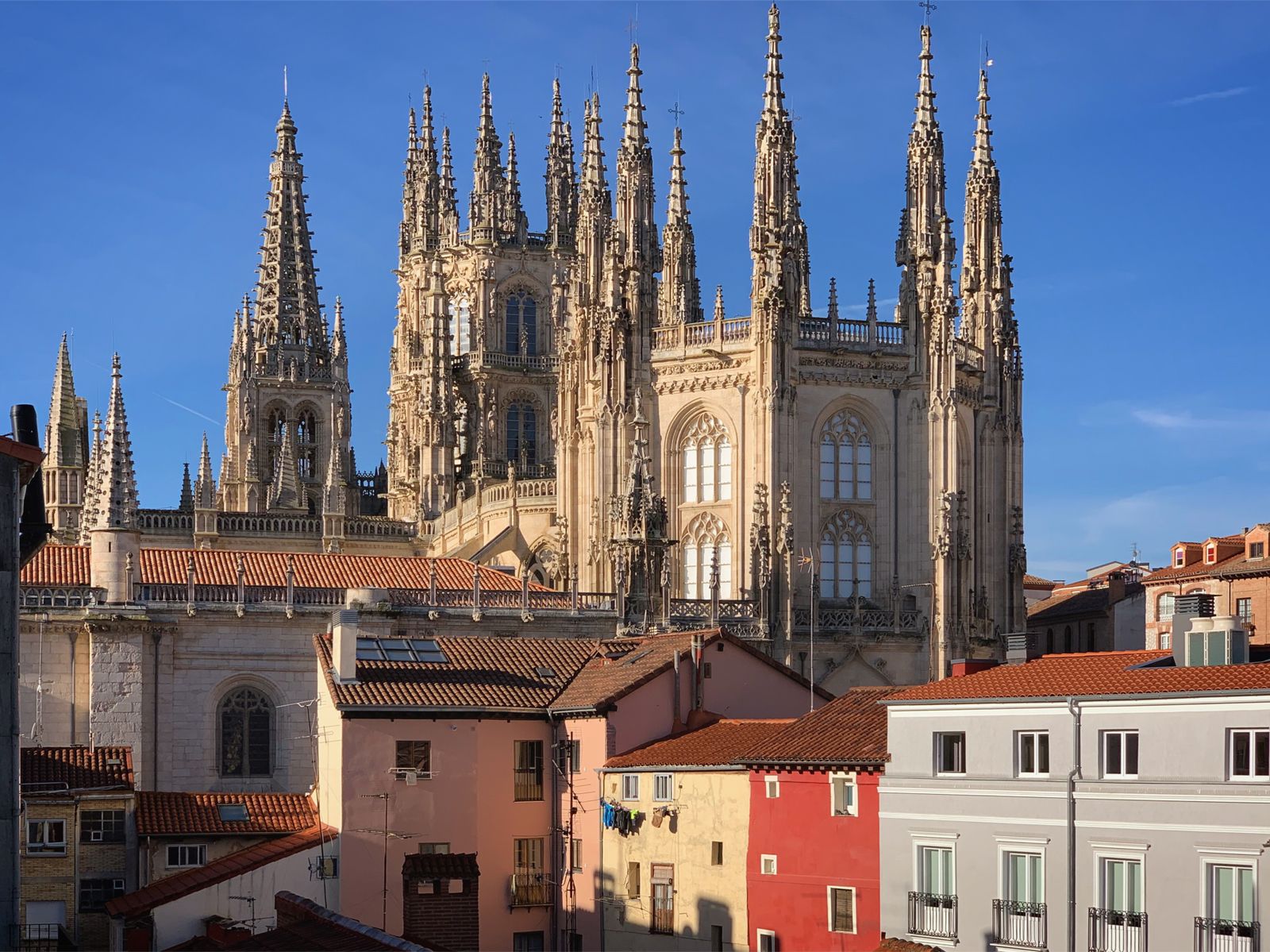 Agujas góticas de la catedral de Burgos sobre los tejados de colores del casco histórico, con el cielo azul de otoño