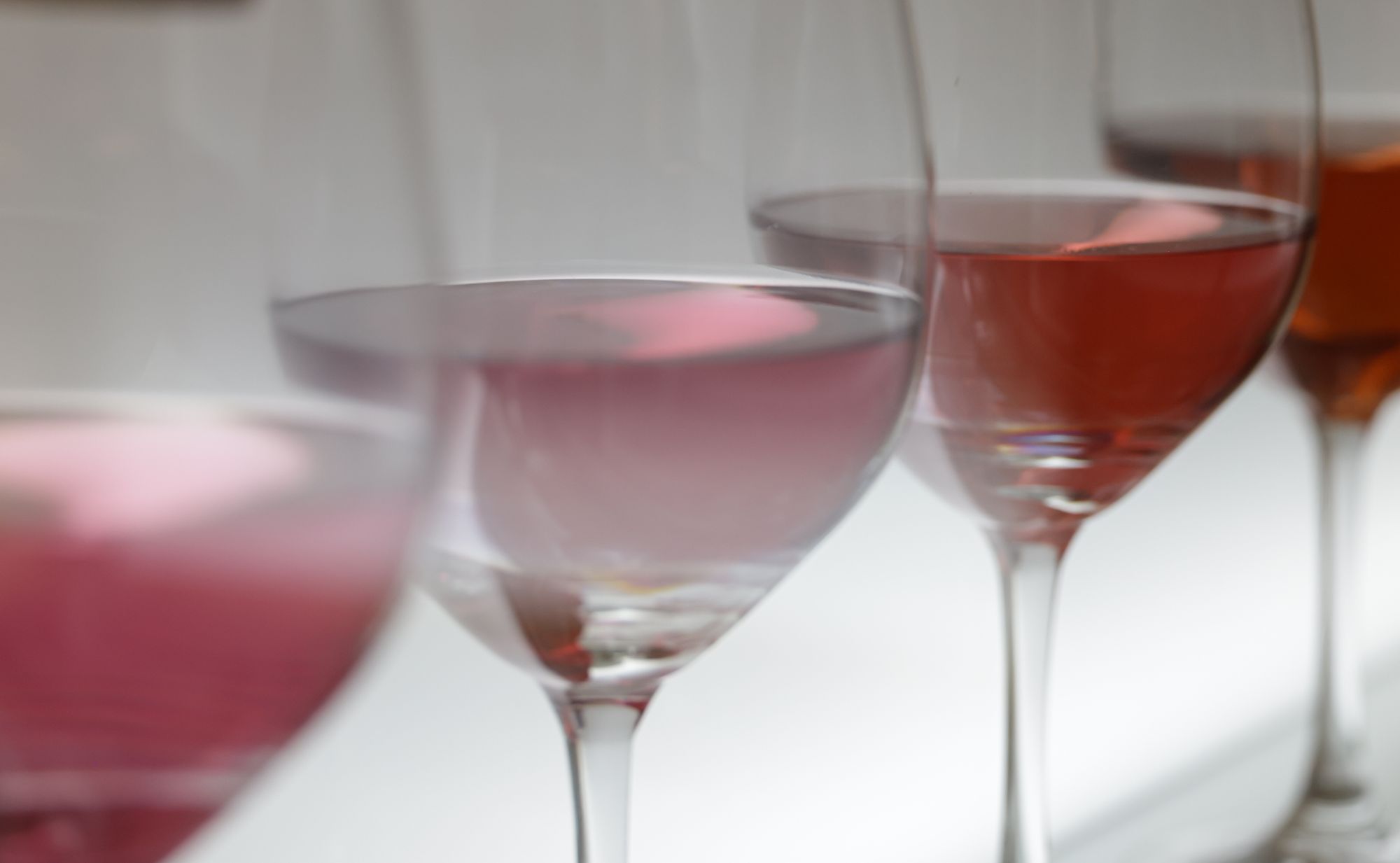 Copas de vino en fila con tonos que van del rosado pálido al clarete anaranjado, la gama de color de los rosados y claretes de Rioja
