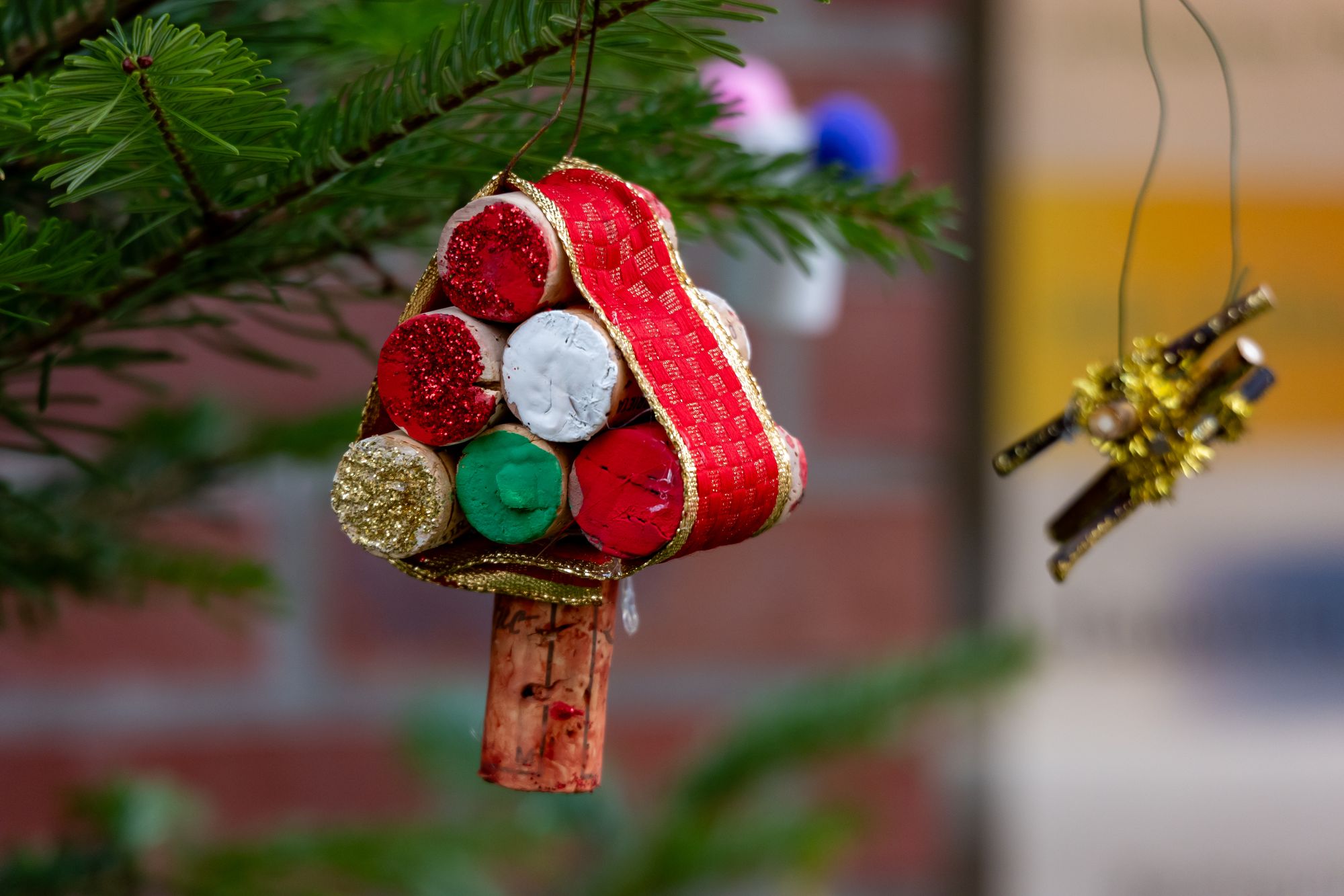 Adorno navideño hecho con corchos de vino y cinta roja colgado de un árbol de Navidad, idea de regalo para amantes del vino de La Rioja